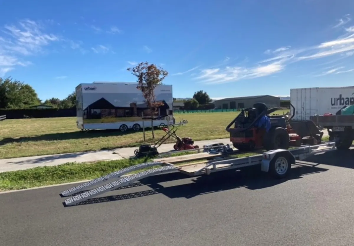 Dirty Deeds Services mowing equipment loaded on a trailer